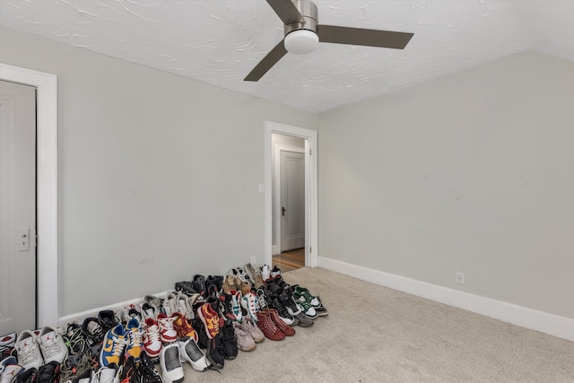 interior space featuring ceiling fan, carpet, and a textured ceiling