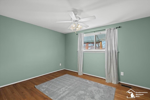 empty room with hardwood / wood-style floors and ceiling fan