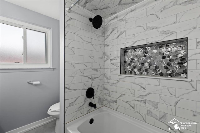 bathroom featuring tiled shower / bath and toilet