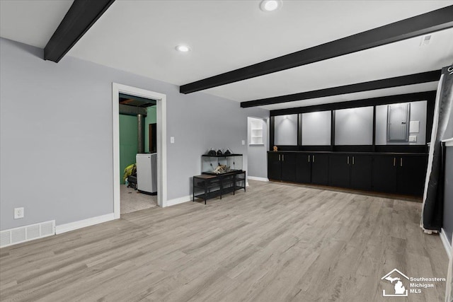 unfurnished living room featuring beamed ceiling and light hardwood / wood-style flooring