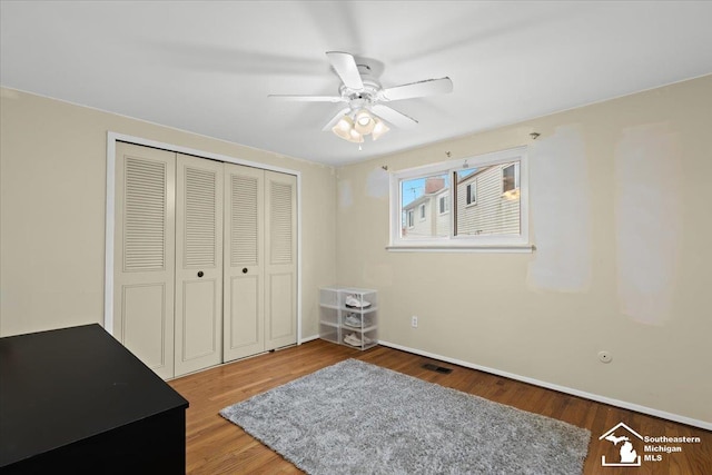 bedroom with hardwood / wood-style floors, a closet, and ceiling fan