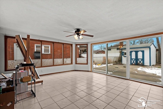 unfurnished sunroom with a wealth of natural light and ceiling fan