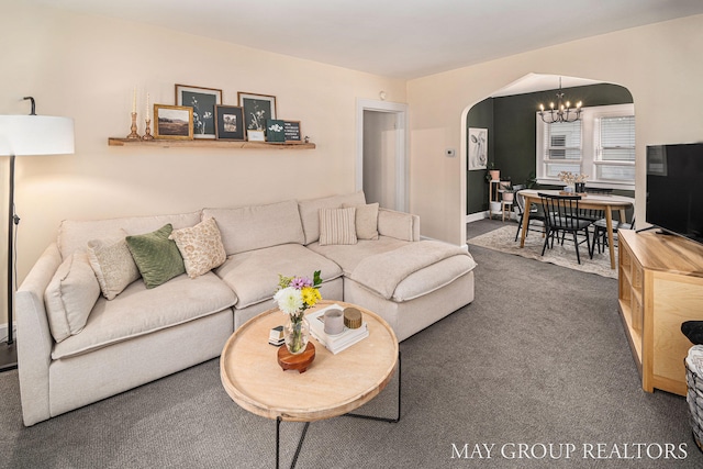 carpeted living room featuring a notable chandelier