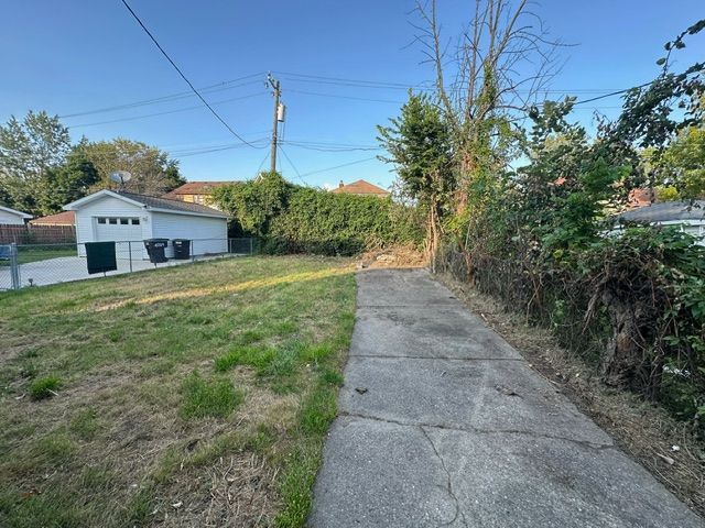 view of yard featuring a garage and an outdoor structure