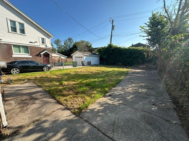 view of yard featuring a garage and an outbuilding