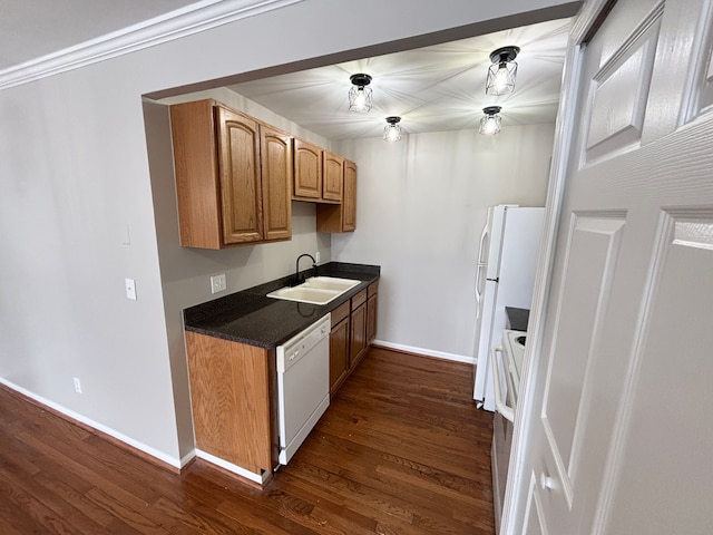 kitchen with crown molding, white appliances, dark hardwood / wood-style floors, and sink