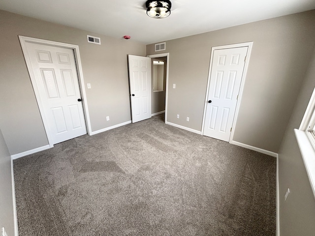 unfurnished bedroom featuring dark carpet