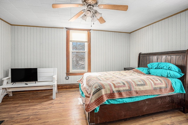 bedroom featuring crown molding, ceiling fan, and wood finished floors