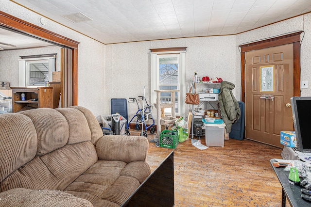 living area featuring wallpapered walls, visible vents, and wood finished floors