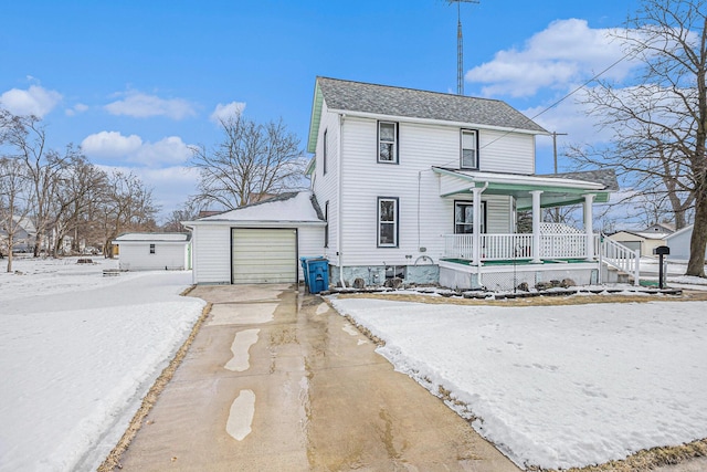 view of front of house featuring a porch, concrete driveway, an outdoor structure, and a garage