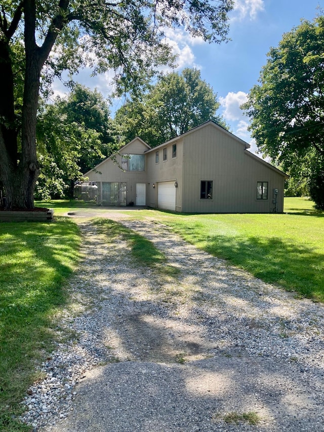 exterior space with a garage and a lawn