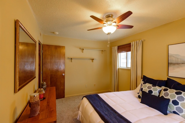 bedroom with a textured ceiling, light carpet, and ceiling fan