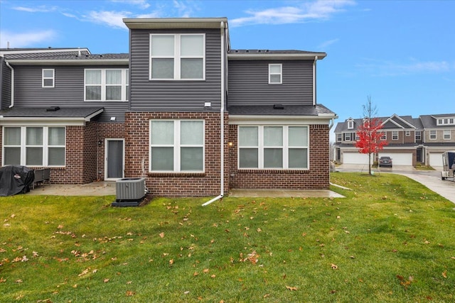 rear view of property featuring central AC, a patio area, and a lawn