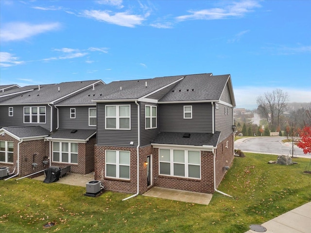 rear view of property with central AC unit, a lawn, and a patio