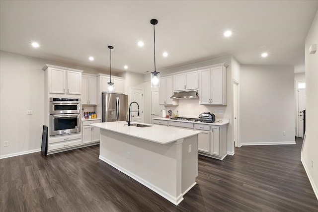 kitchen with white cabinetry, stainless steel appliances, a kitchen island with sink, and sink