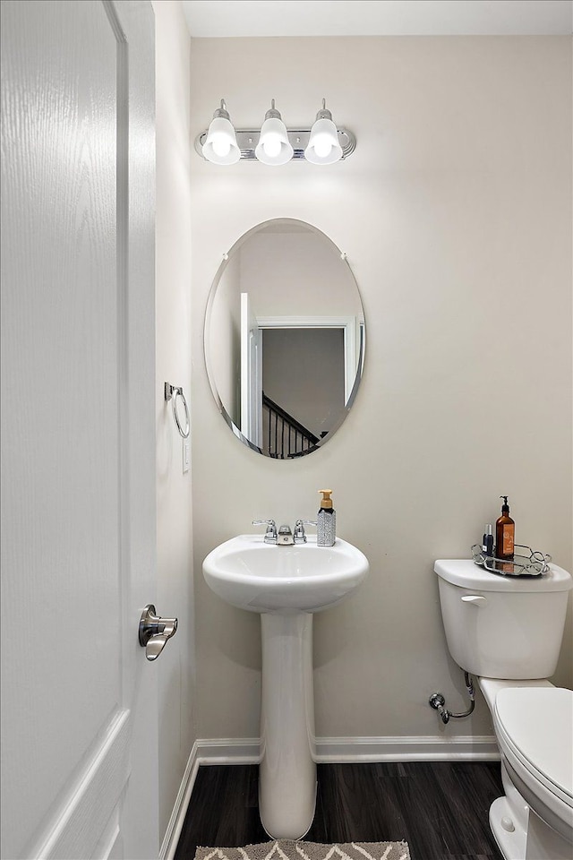 bathroom featuring hardwood / wood-style flooring and toilet