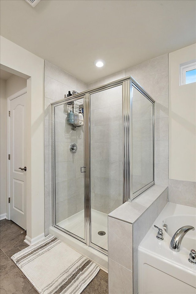 bathroom featuring independent shower and bath