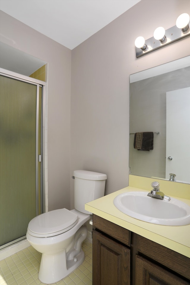 bathroom featuring vanity, tile patterned floors, a shower with door, and toilet