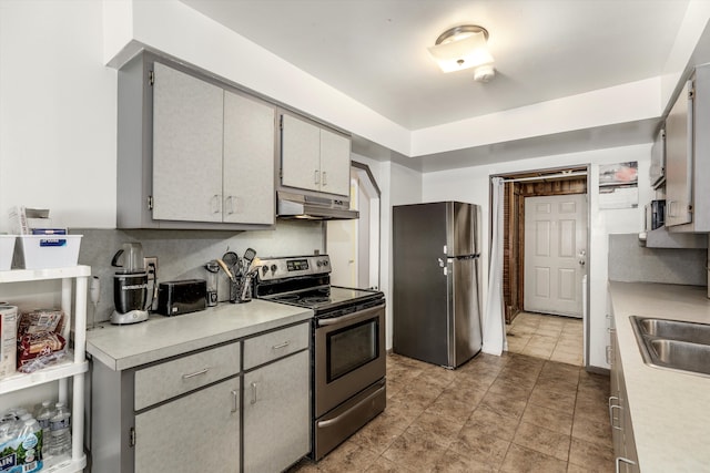 kitchen featuring tasteful backsplash, sink, gray cabinets, and stainless steel appliances