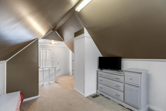 bonus room with light carpet and vaulted ceiling