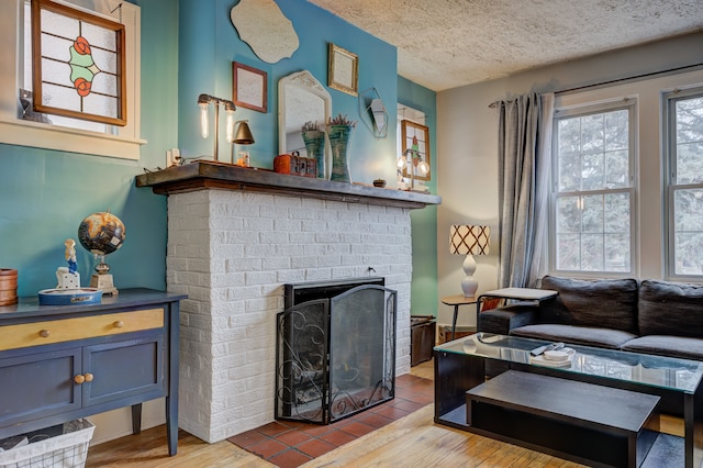 living area featuring a fireplace, a textured ceiling, and wood finished floors