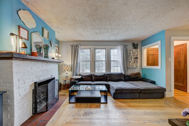 living area featuring a fireplace, a textured ceiling, and wood finished floors