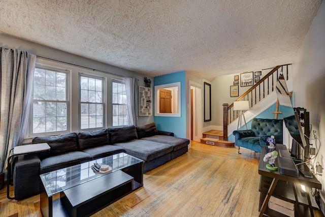 living room with a textured ceiling, stairs, and hardwood / wood-style floors