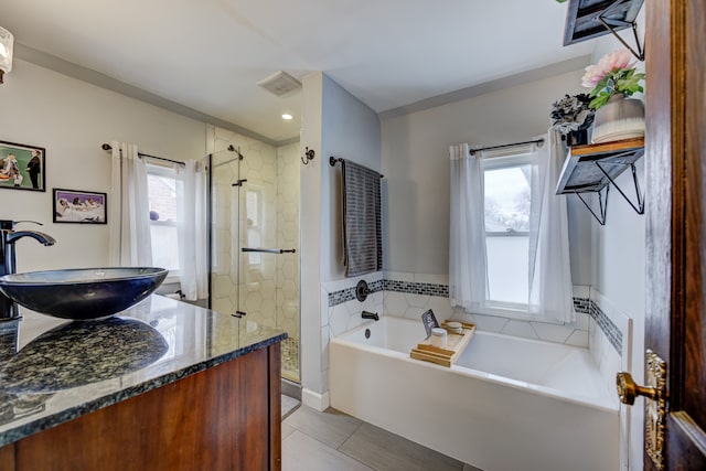 full bathroom featuring a stall shower, vanity, a garden tub, and tile patterned floors