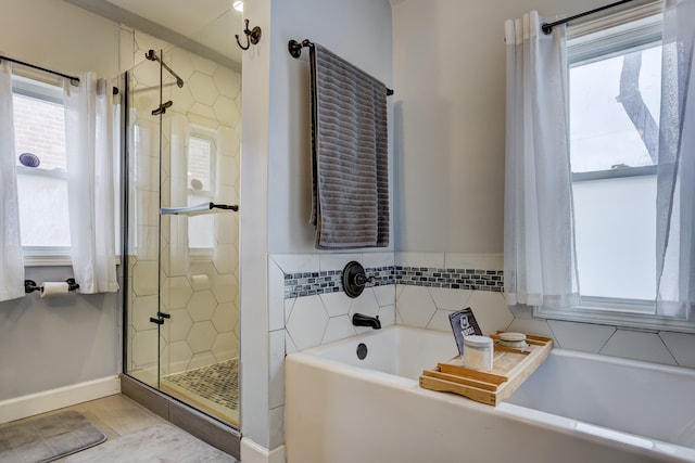 full bath featuring a garden tub, a shower stall, and a wealth of natural light