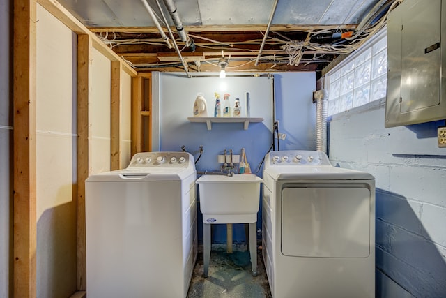 clothes washing area featuring laundry area, electric panel, washer and clothes dryer, and a sink