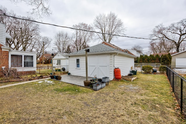 exterior space with a patio area, a fenced backyard, a shingled roof, and a lawn