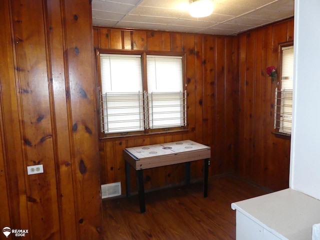 miscellaneous room featuring dark wood-type flooring and wooden walls