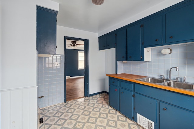 kitchen featuring blue cabinetry, ceiling fan, and sink