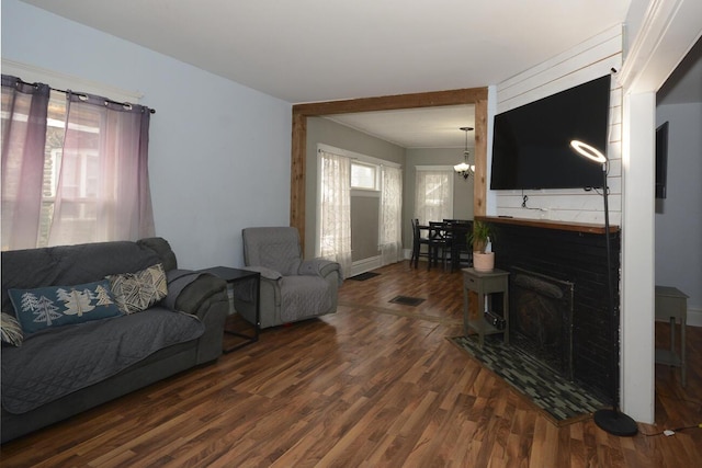 living room with dark hardwood / wood-style flooring and a notable chandelier