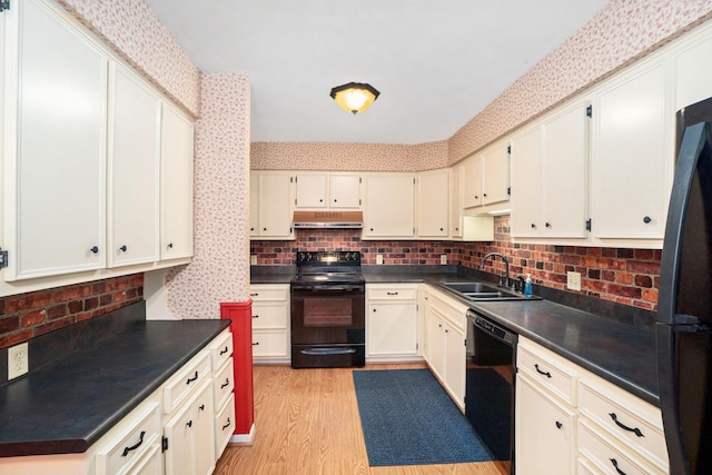 kitchen featuring light wood-type flooring, backsplash, sink, and black appliances