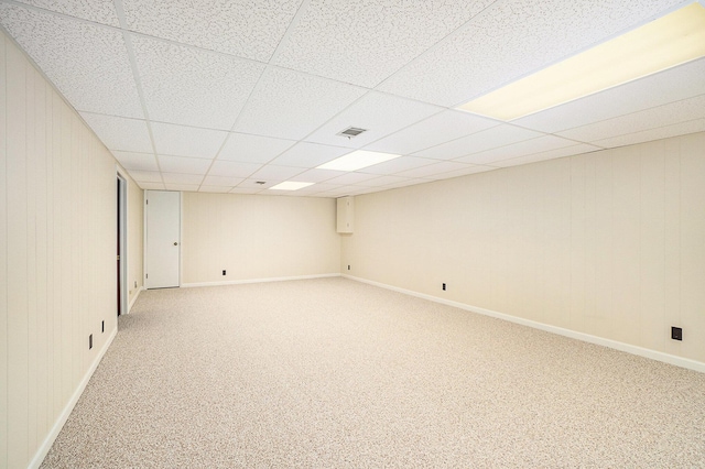 carpeted spare room featuring a drop ceiling