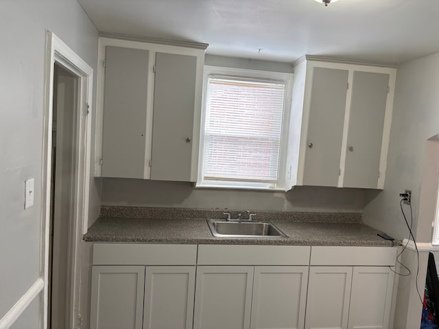 kitchen featuring white cabinetry and sink