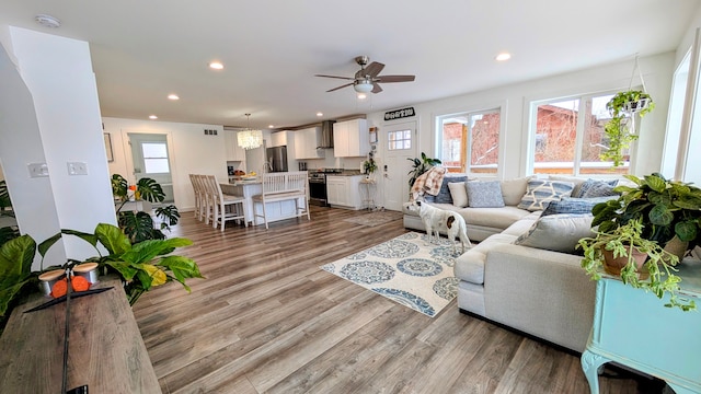 living room featuring ceiling fan and light hardwood / wood-style floors