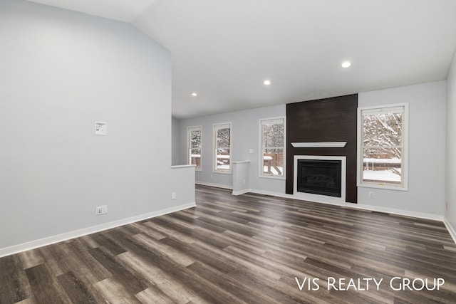 unfurnished living room with a large fireplace, baseboards, dark wood finished floors, and lofted ceiling
