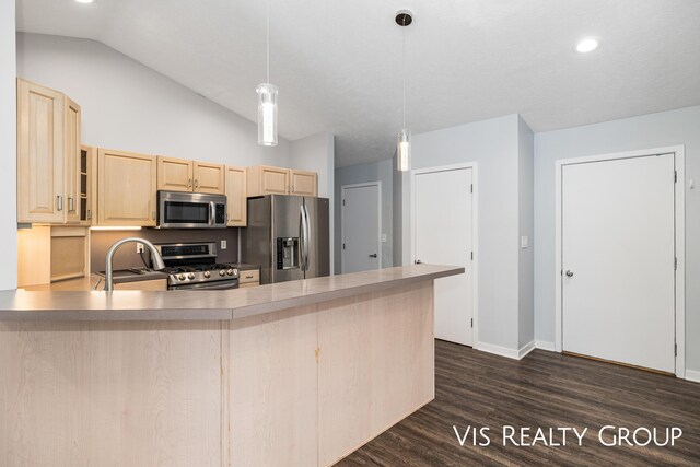 kitchen with light countertops, hanging light fixtures, appliances with stainless steel finishes, glass insert cabinets, and a sink