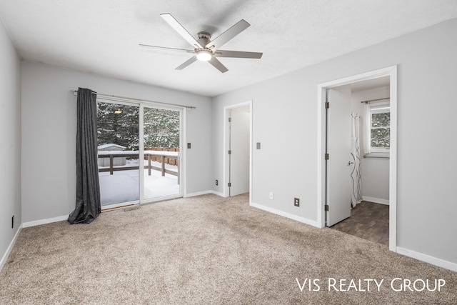 unfurnished bedroom featuring access to outside, carpet flooring, and multiple windows