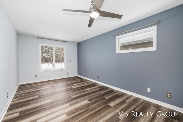 empty room featuring ceiling fan, baseboards, and dark wood-type flooring