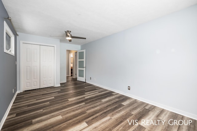 unfurnished bedroom featuring dark wood-type flooring, a closet, ceiling fan, and baseboards