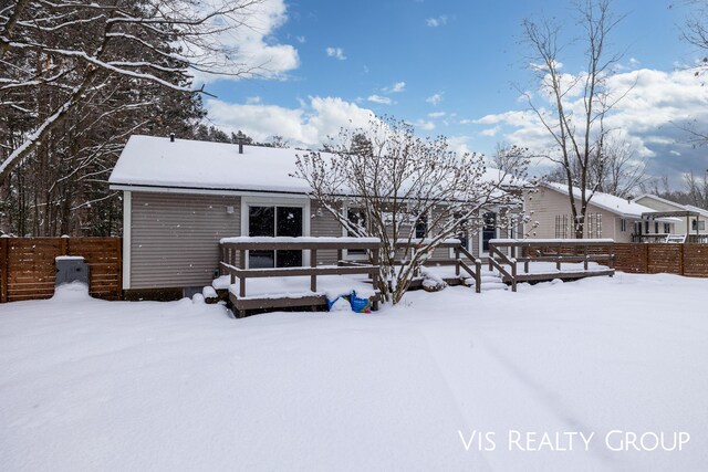 snow covered back of property featuring fence