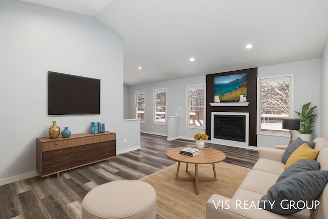 living area with lofted ceiling, a fireplace, wood finished floors, and baseboards