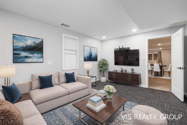living room with recessed lighting, visible vents, dark carpet, and baseboards
