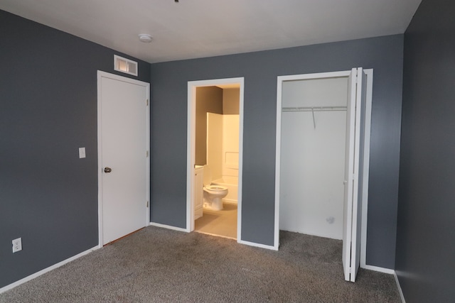 unfurnished bedroom featuring ensuite bathroom, carpet flooring, and a closet