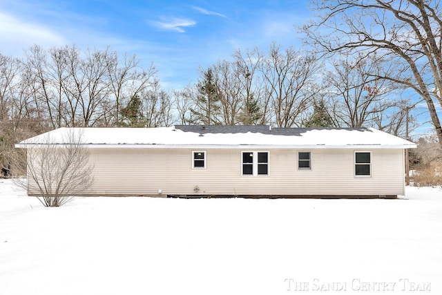 view of snow covered rear of property