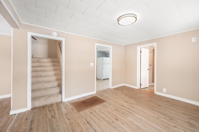 empty room featuring crown molding and light wood-type flooring