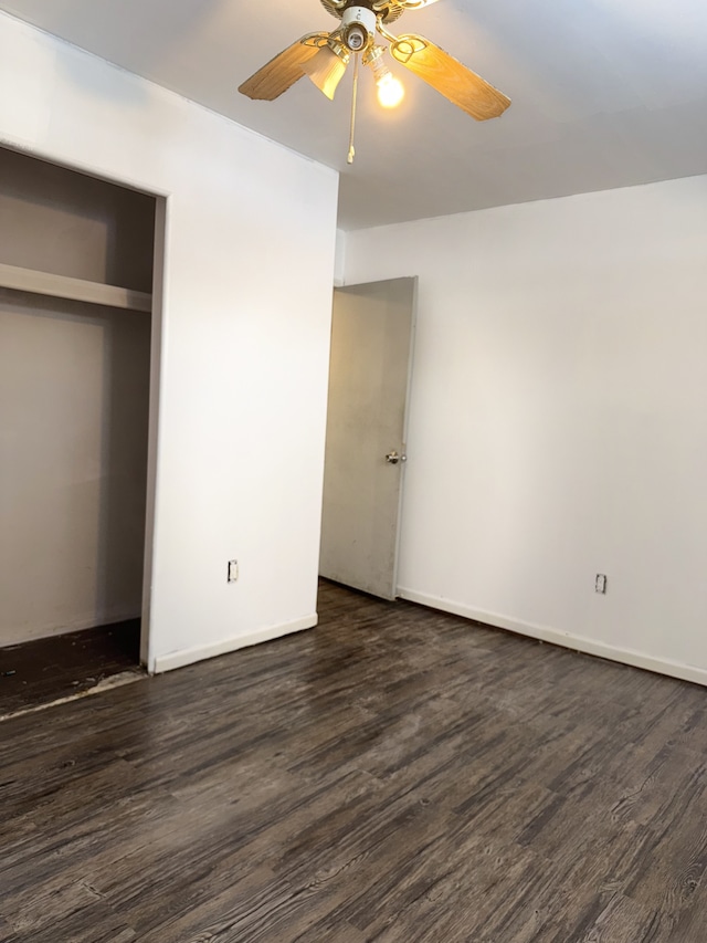 unfurnished bedroom with ceiling fan, dark hardwood / wood-style flooring, and a closet